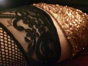 Image of my thigh with fishnet stockings and golden sparkly shorts